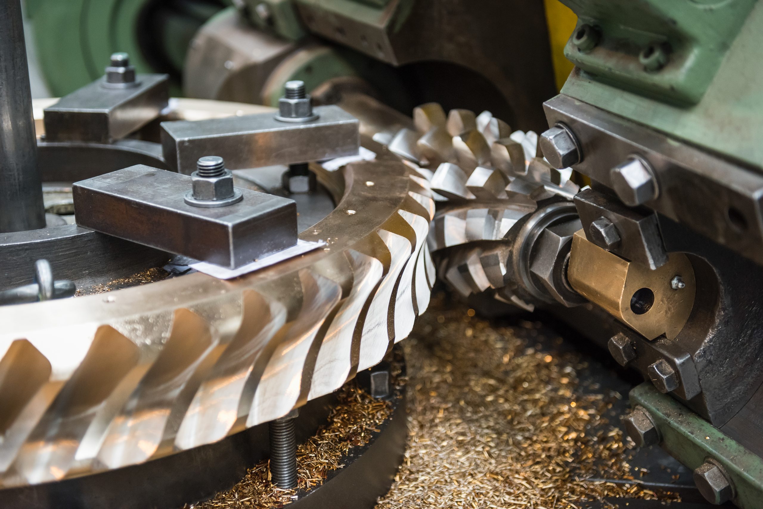 Bronze worm gear with specialist cutting tool in lathe in engineering factory, close up